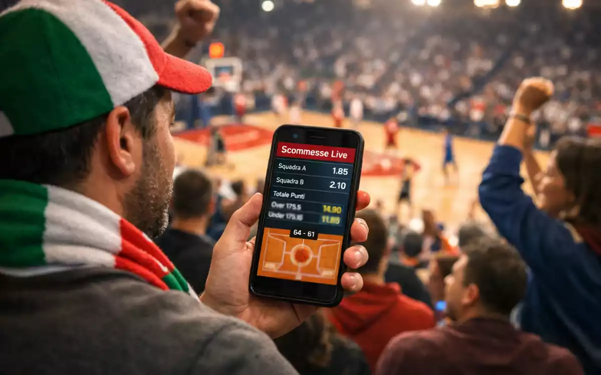 Tifoso con smartphone che segue partita di basket in diretta