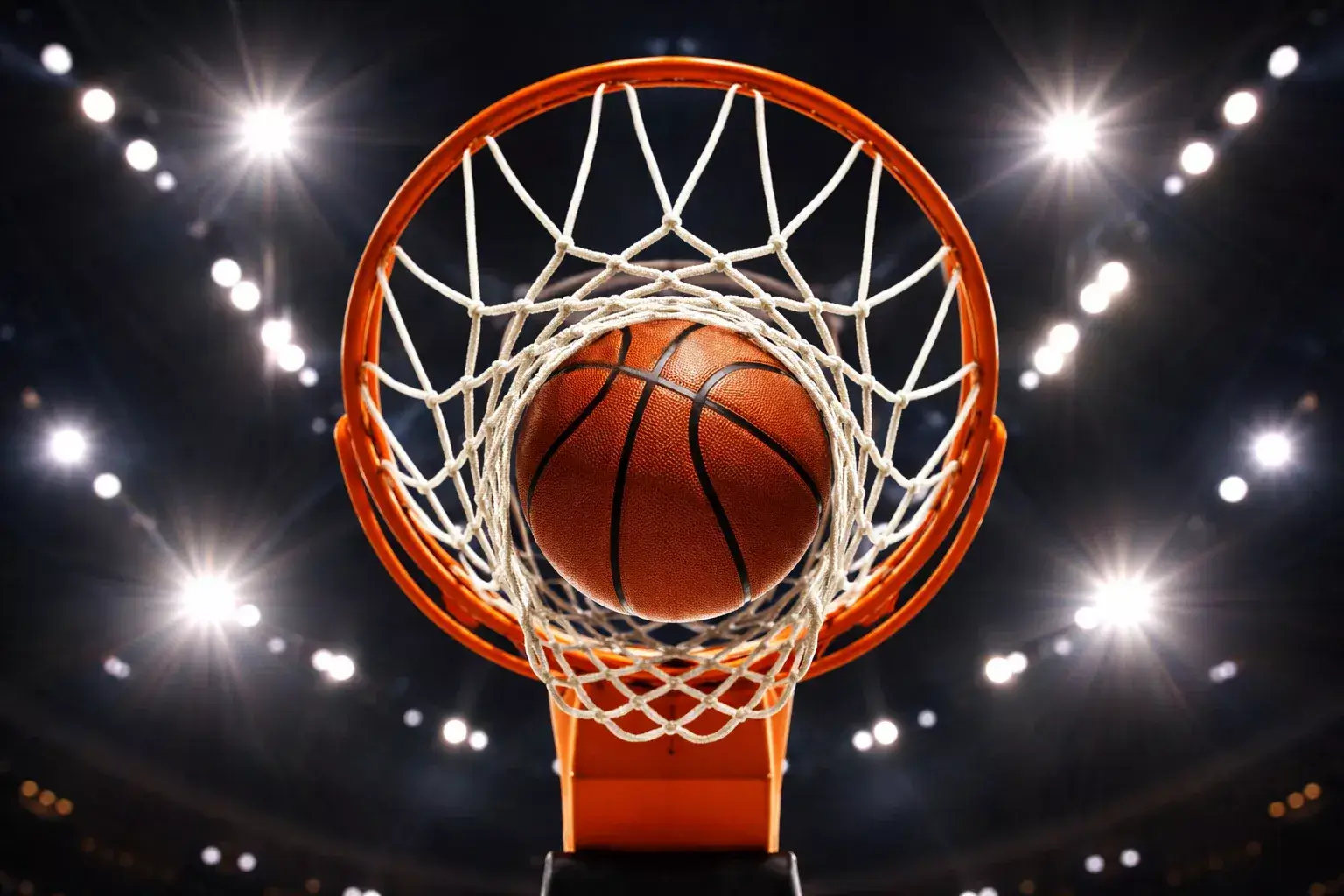 Canestro da basket visto dal basso con il pallone che entra nella retina